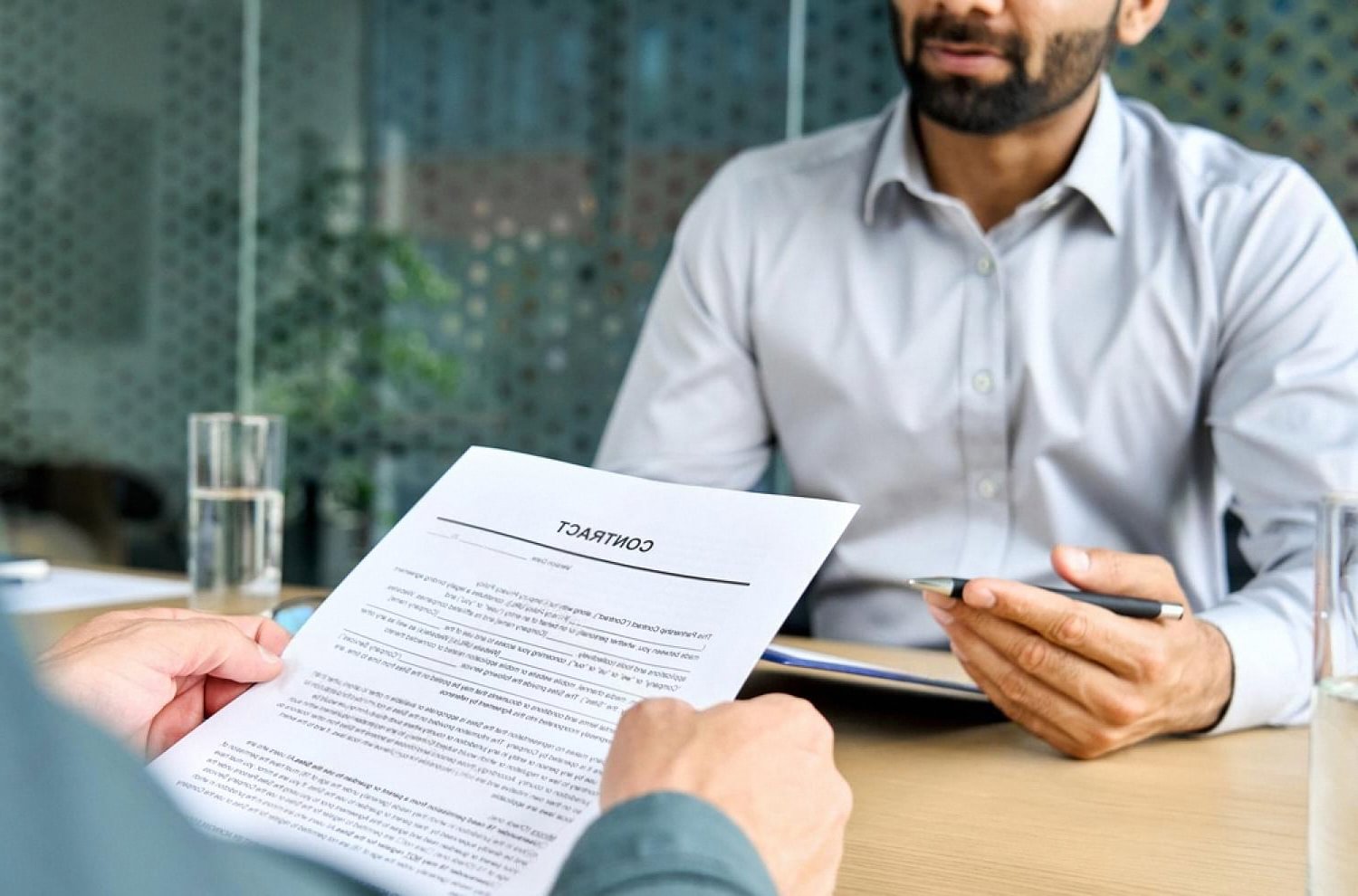 Company director handing over a signed contract after due diligence review