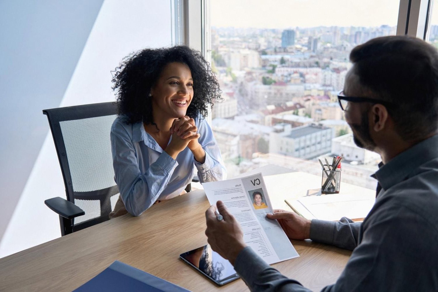 Recruiter reviewing an executive candidate's CV during a background check interview