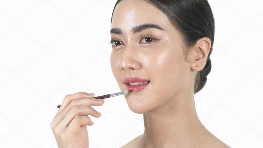 Technician applying lip shading pigment during a treatment session