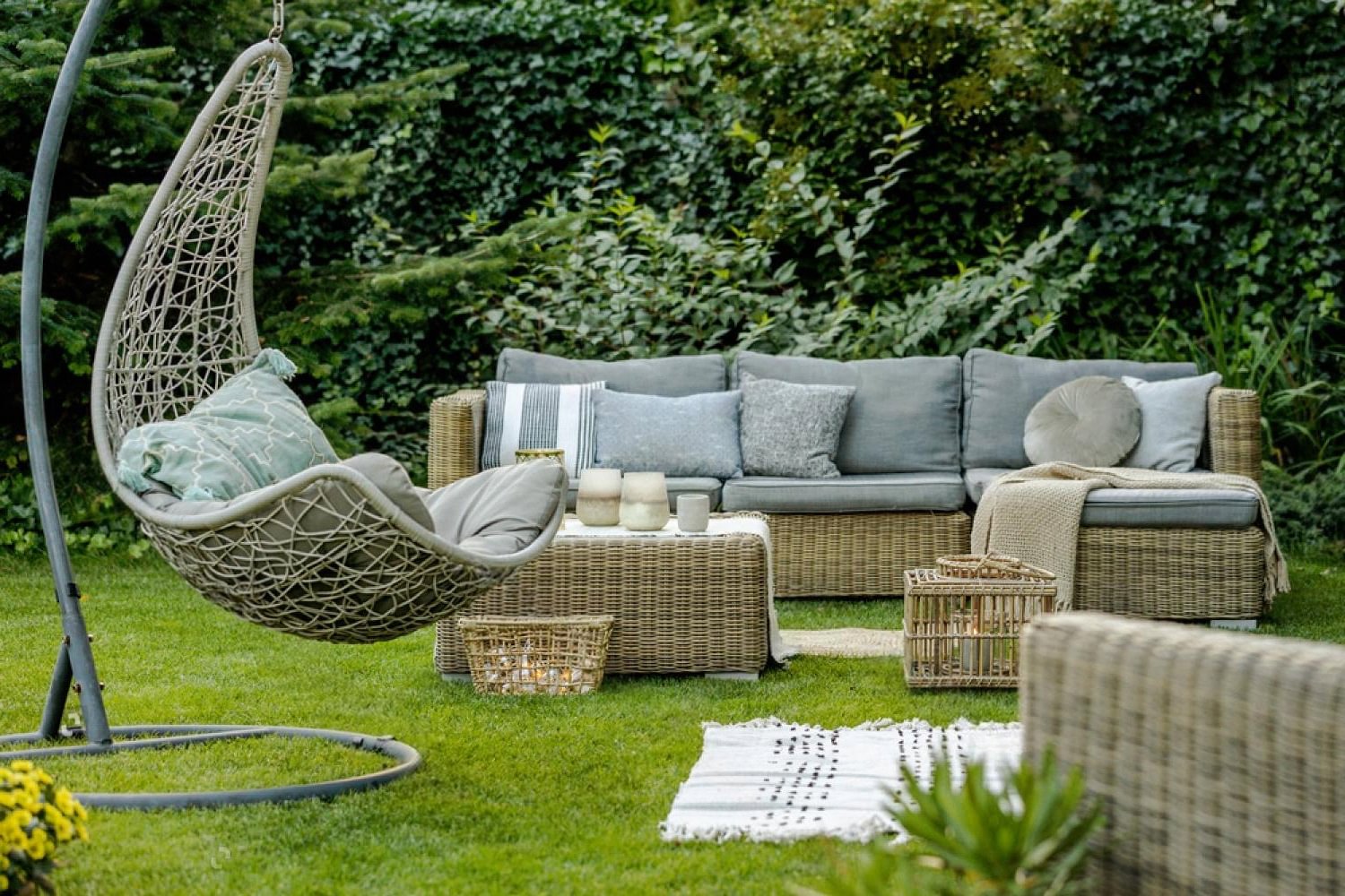 Rattan outdoor sofa and hanging chair set up in a Dubai garden space