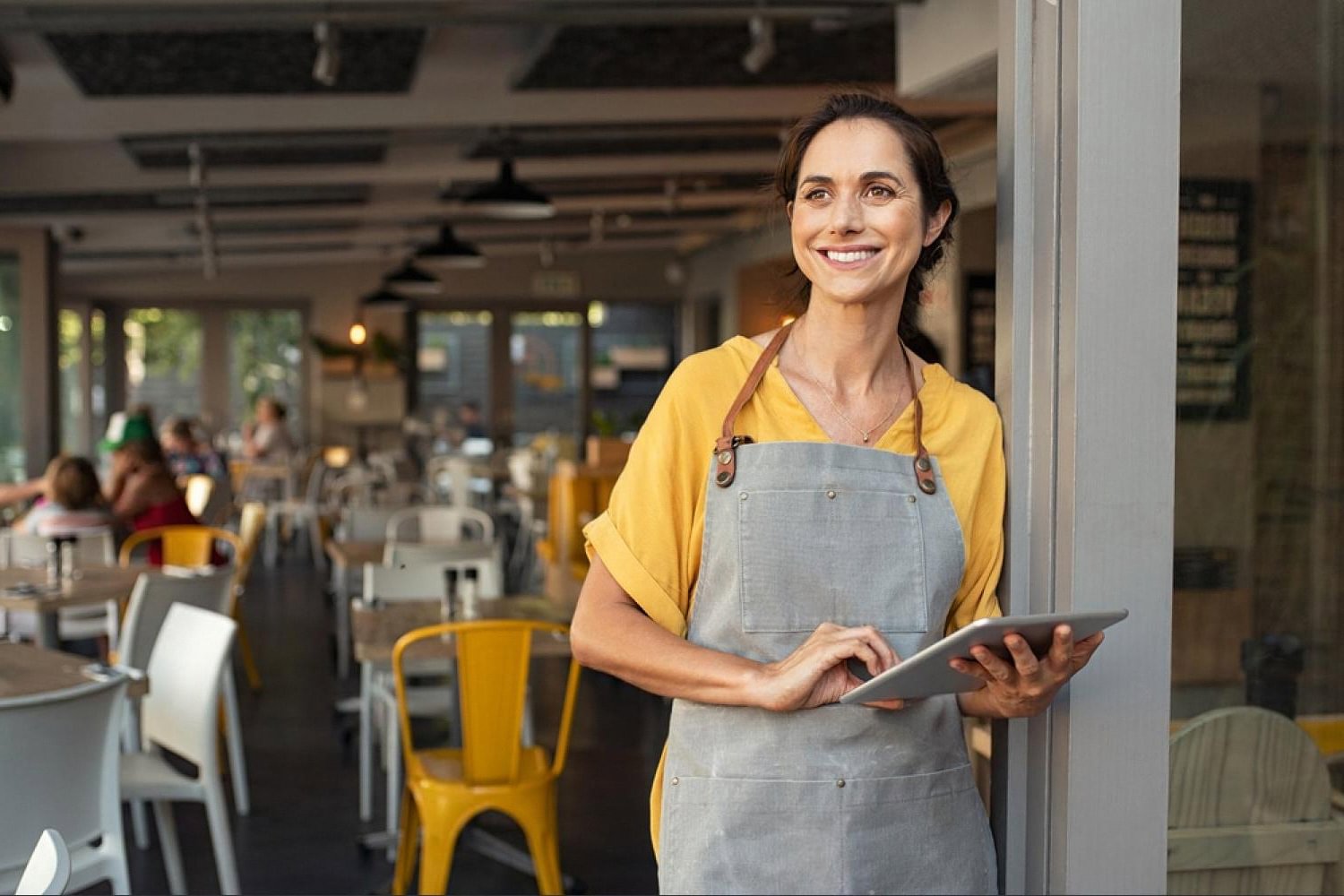 Small business owner in the UAE holding a tablet, planning her online presence